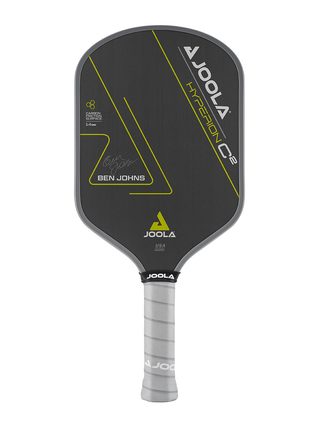 White Background Image: Ben Johns Hyperion C2 Pickleball paddle. Black surface with yellow lines and Ben Johns' signature. Grey handle and grey edge guard with white JOOLA logo.